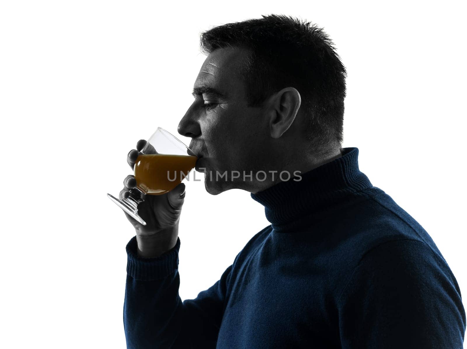 one caucasian man drinking orange juice portrait in silhouette studio isolated on white background