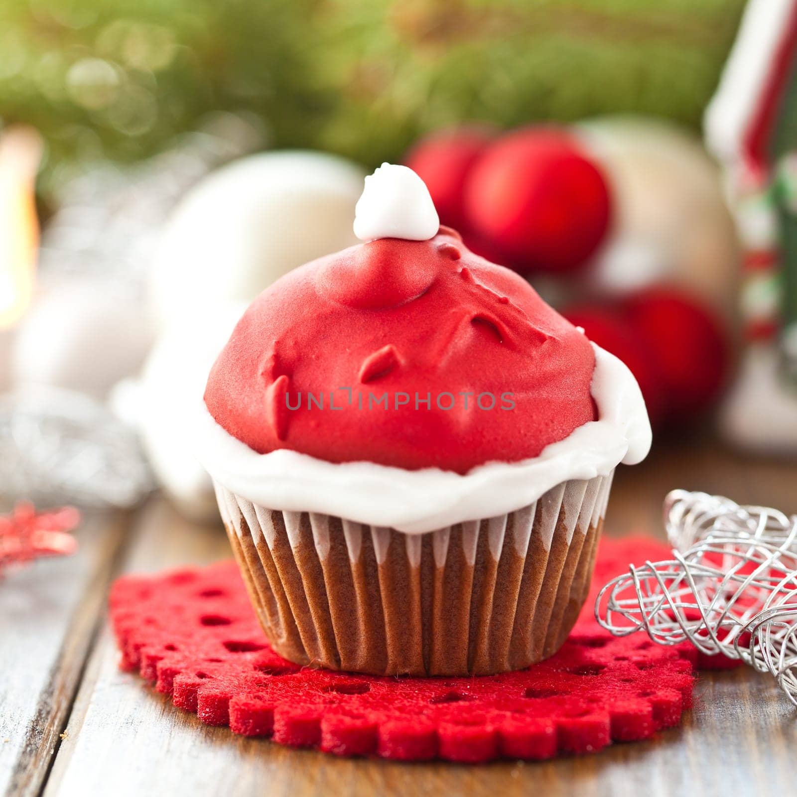 Small cupcake with Santa Claus cap made of frosting