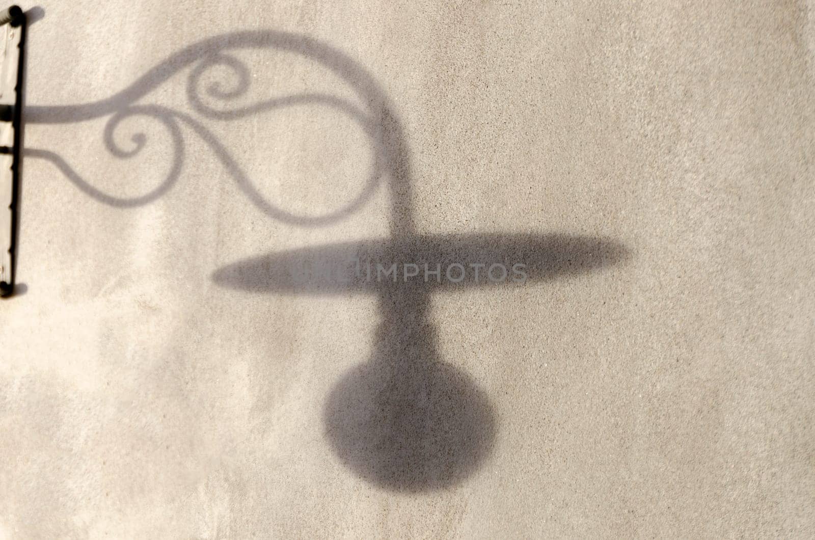 shadow of a lamppost on a wall at sunset