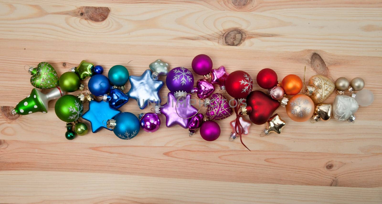 Colourful Christmas tree baubles on wooden background