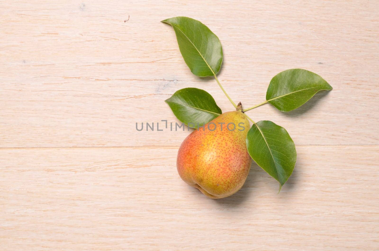 Fresh pear with leaves on a wooden background with space for text