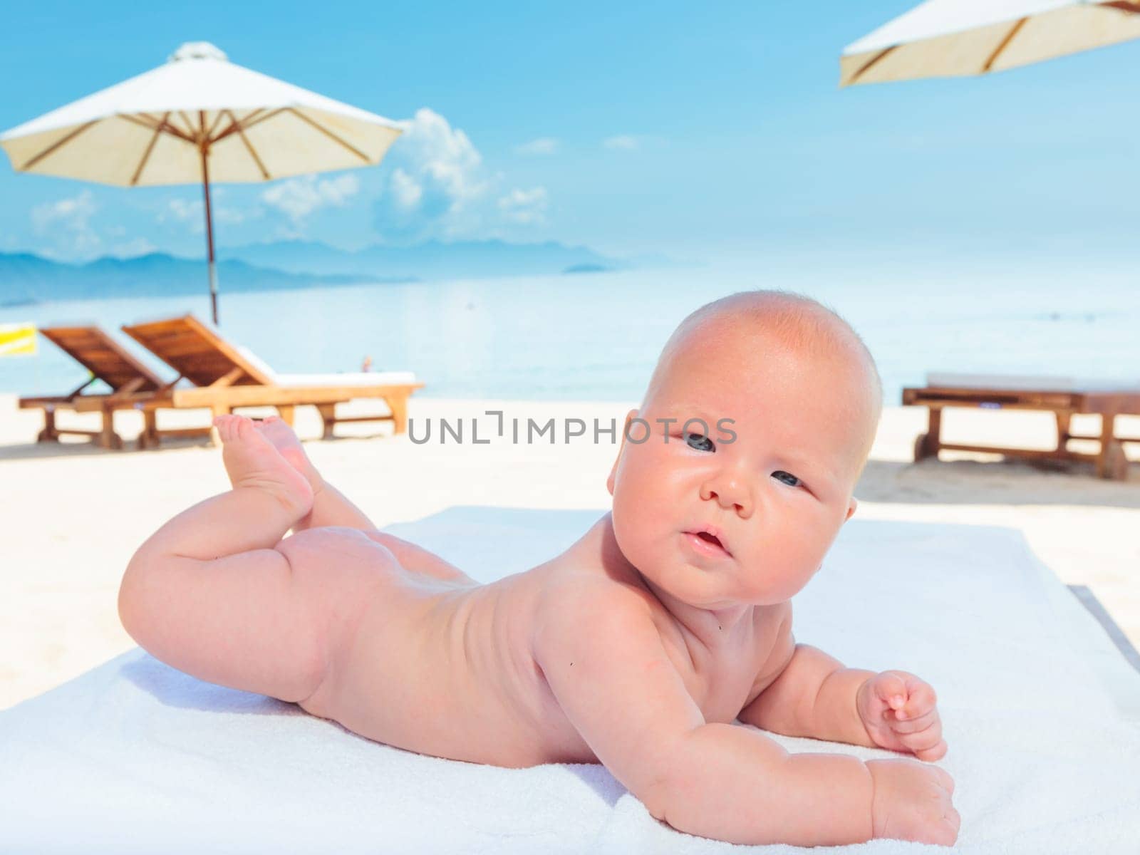 Cute baby laying on the sunbed at the beach