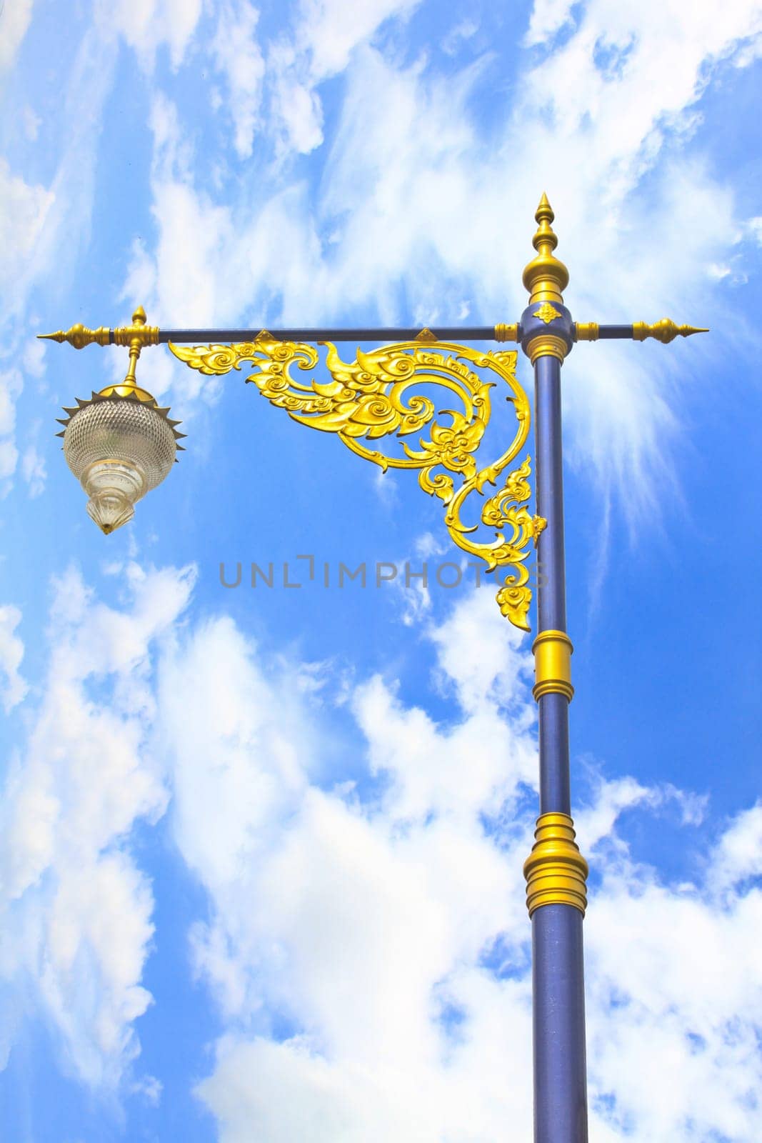 golden lighting pole on blue sky, Thai style statue
