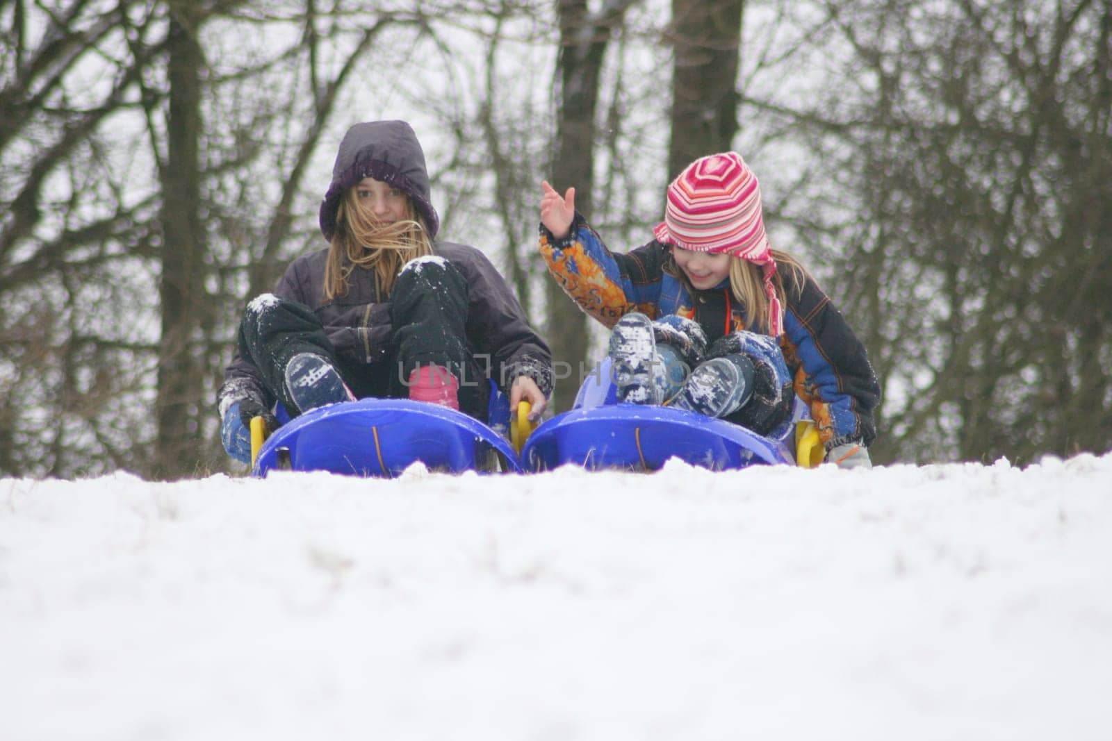 two blonde girls have fun in the snow