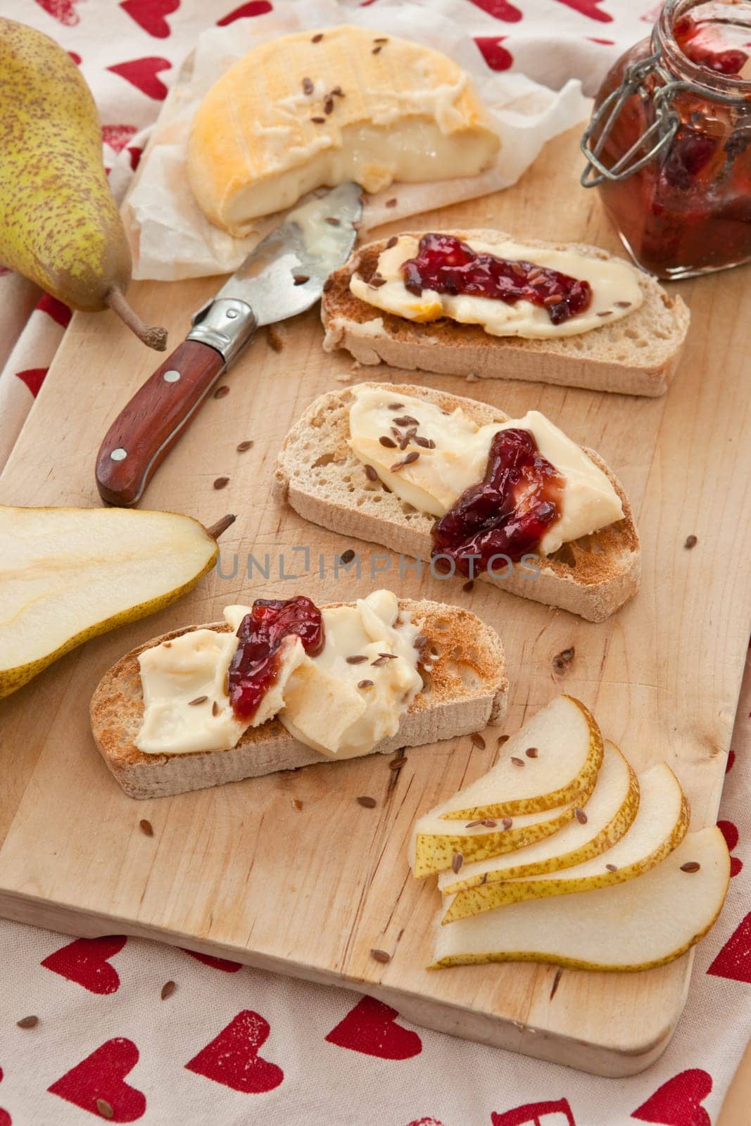 Caese,bread and fresh pears on cutting board
