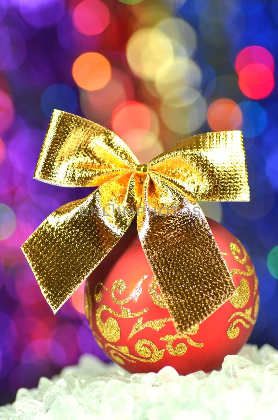 christmas decoration, red Christmas ball with golden bow in bokeh background