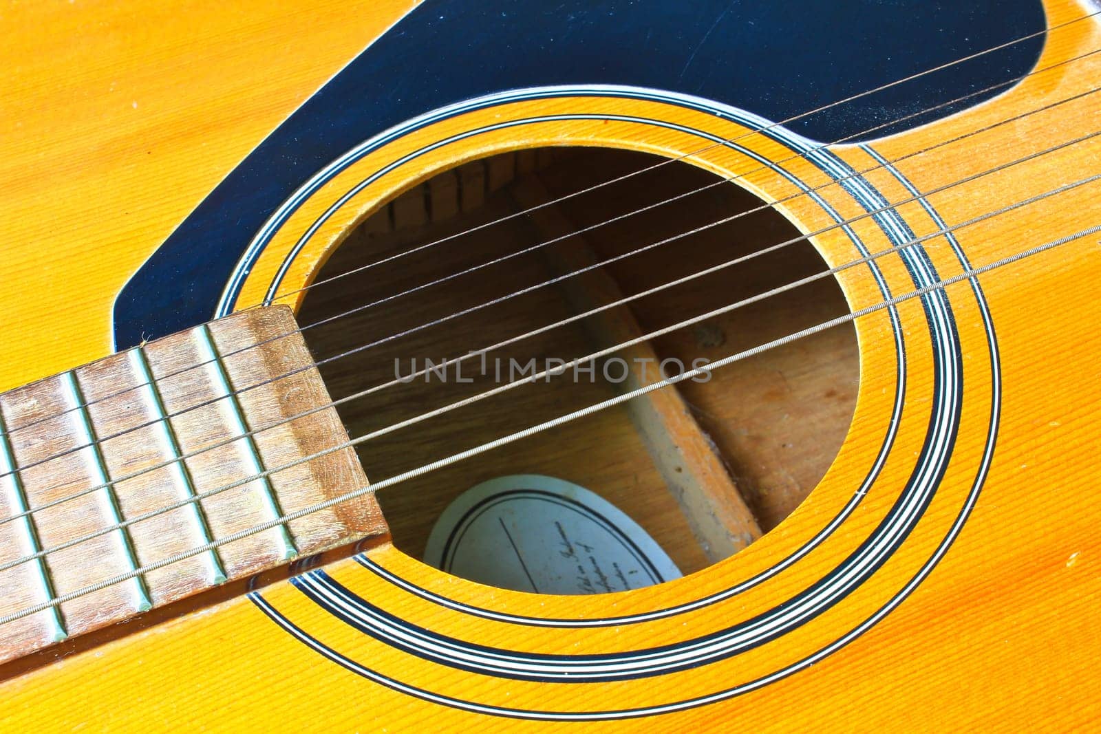 Acoustic guitar wood color close - up. The guitar background