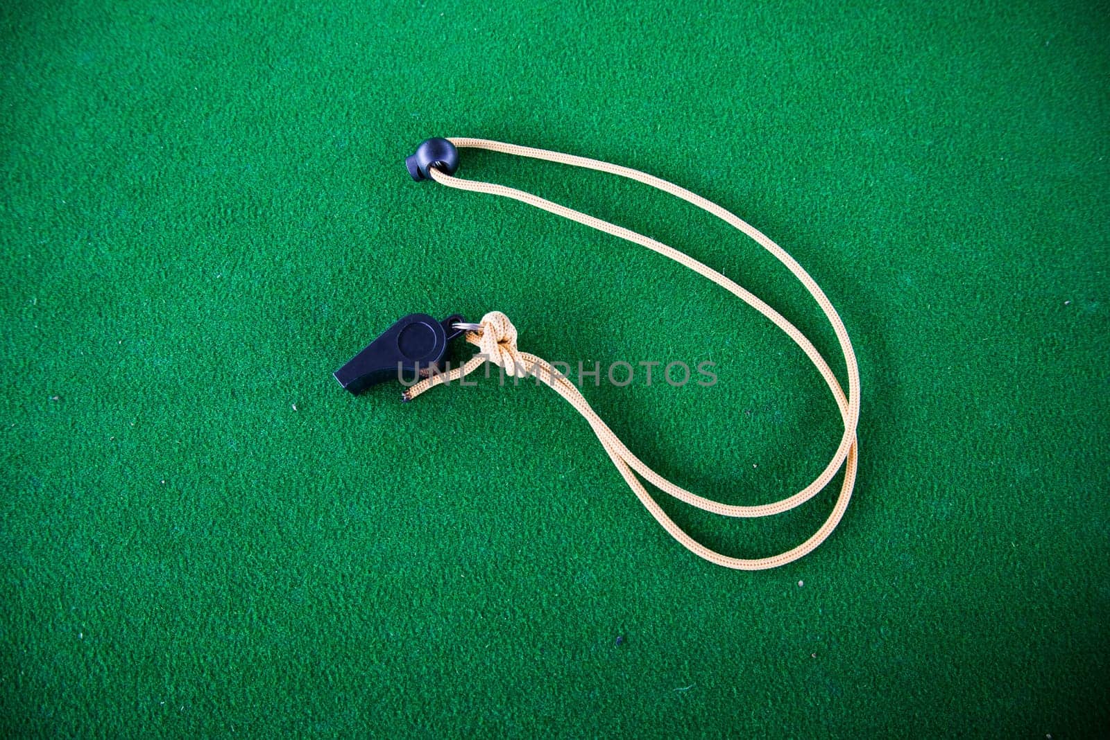 The whistle on the green carpet background.