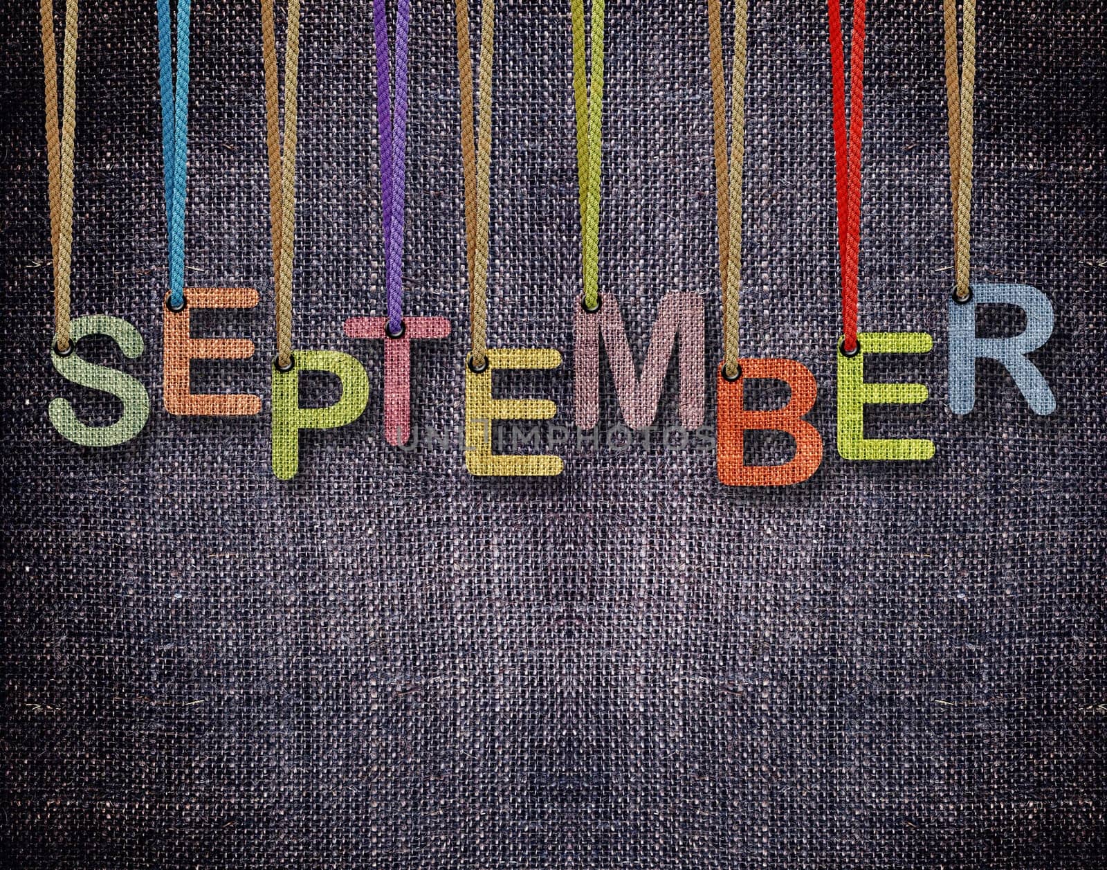 September letters hanging strings with blue sackcloth background.