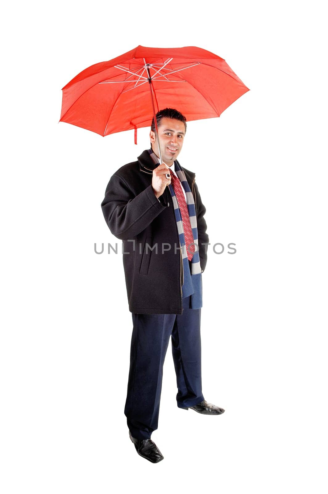 A young tall man in a black coat standing in the studio, holding an.red umbrella, for white background..