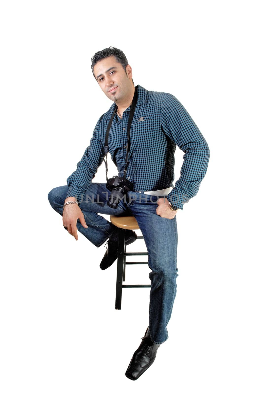 A young handsome man sitting on a chair with his camera around his neck,.for white background..