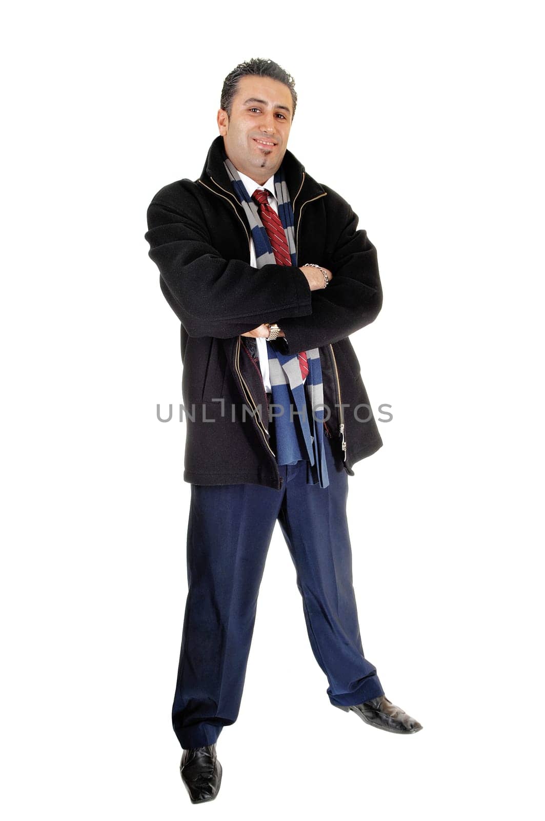 A tall and young businessman standing in a black coat for.white background with his arms crossed..