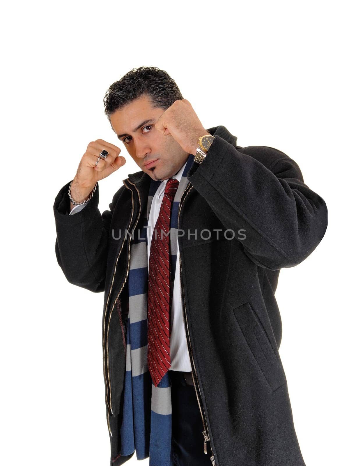 A young handsome man in a black coat standing for white background.with his fists up looking for a fight..