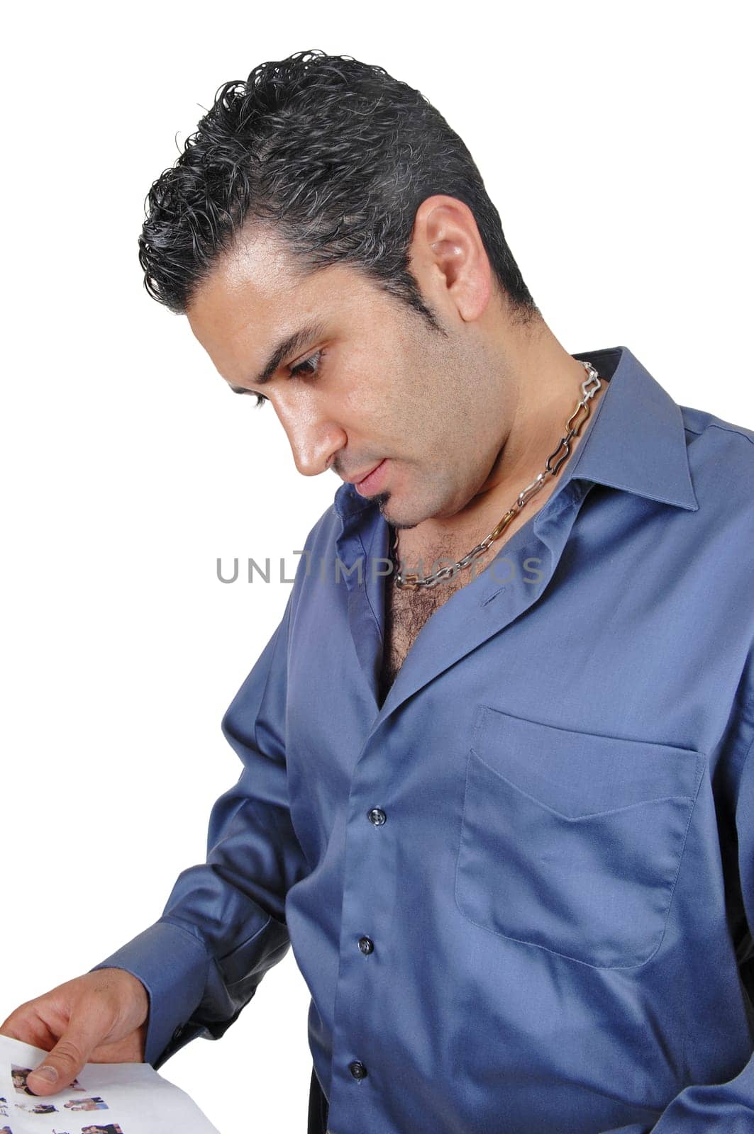 A young man in a blue shirt standing whit some paper in his hand.looking down and thinking, for white background..