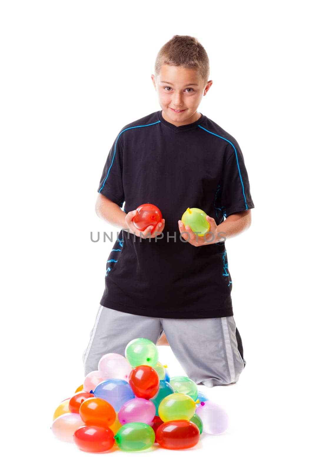 Boy with a pile of water balloons isolated on white background