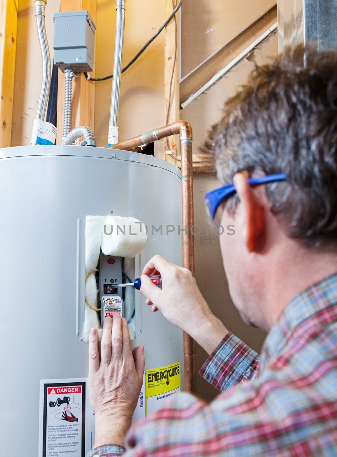 A technician is performing maintenance on a residential water heater
