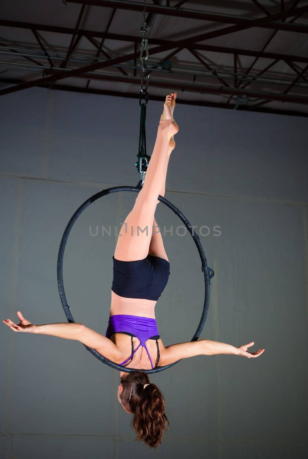 Beautiful woman gymnast performing aerial exercises