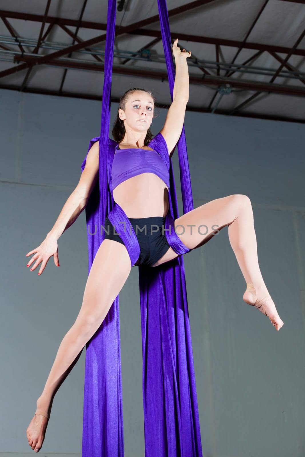 Beautiful woman gymnast performing aerial exercises