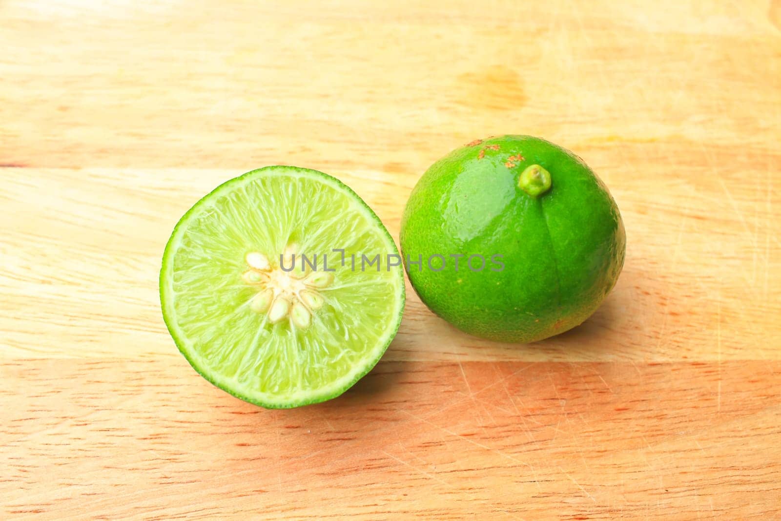 Fresh organic cut limes on wooden cutting board
