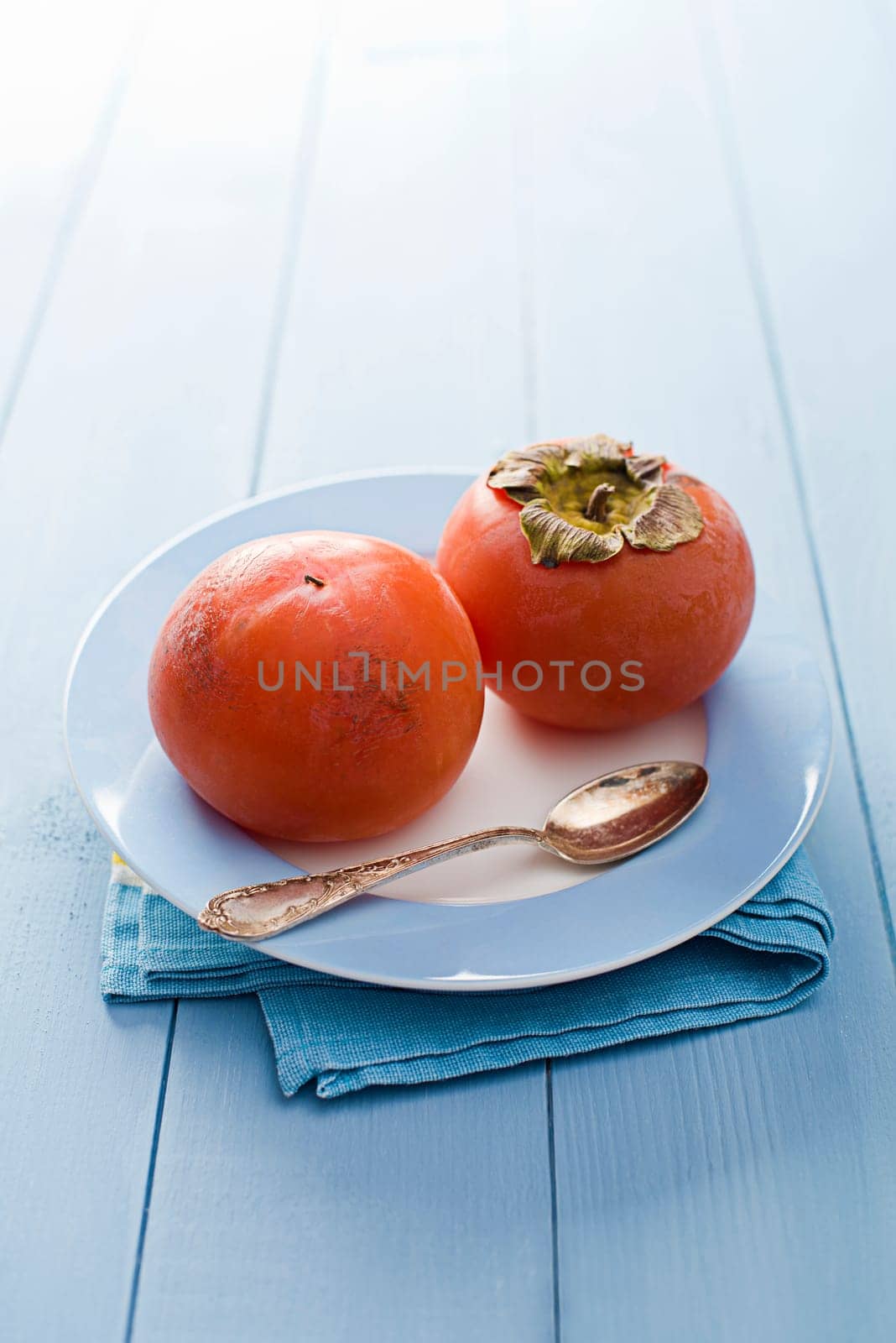 Persimmons - kaki on wooden table close up