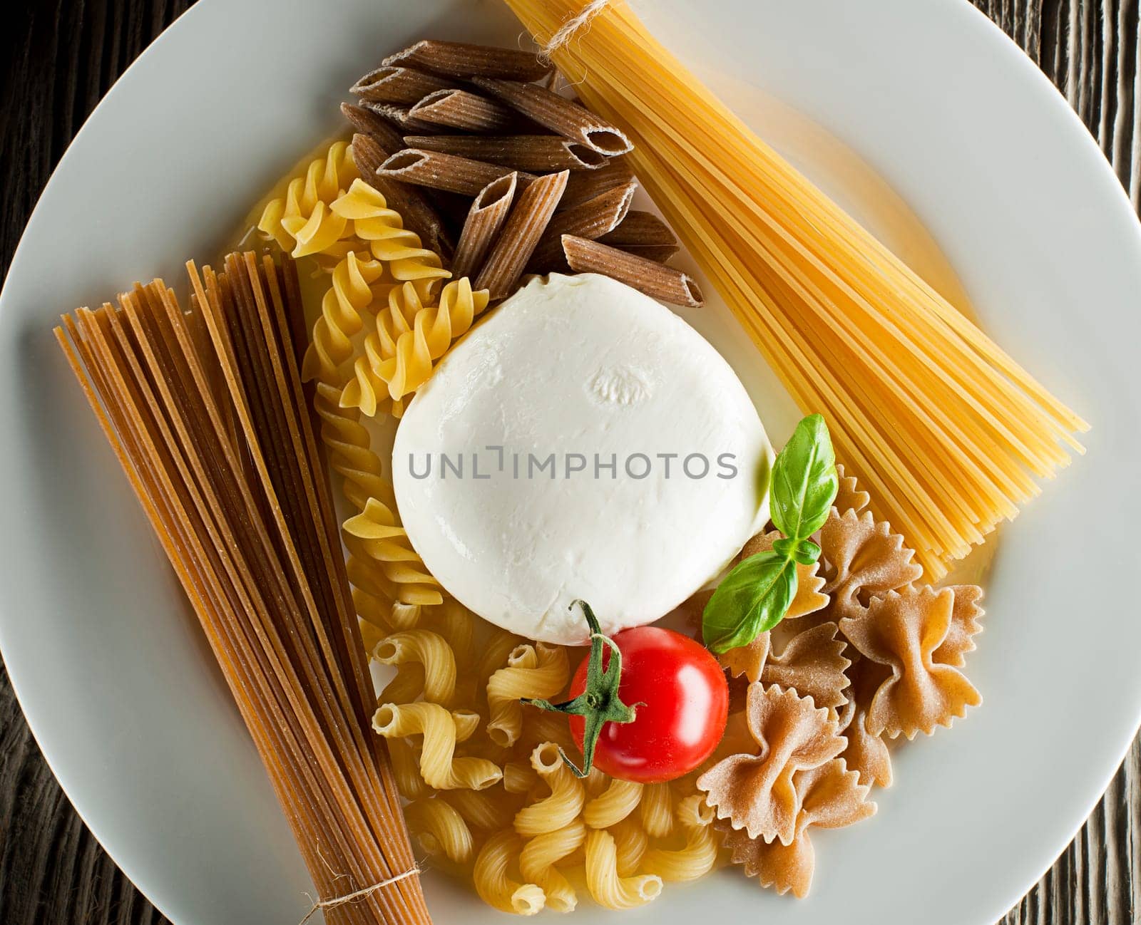 Raw pasta with basil, mozzarella and tomato overhead shoot
