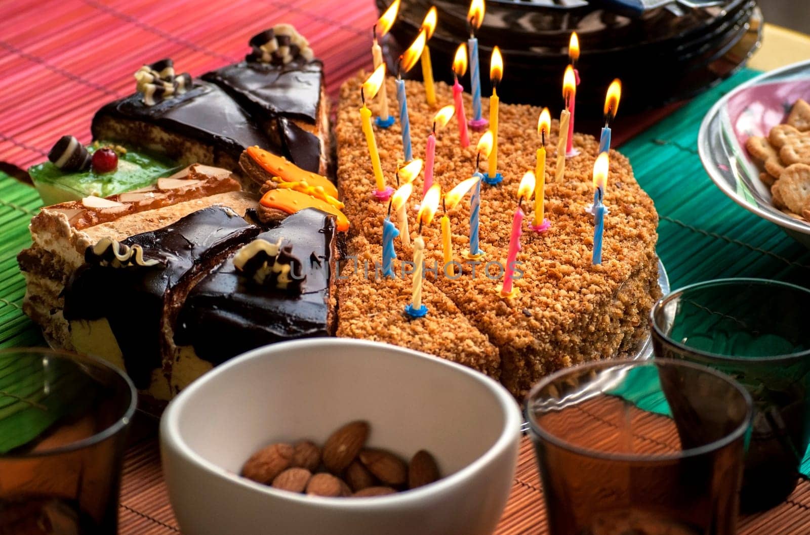 Various pieces of cake with lit candles