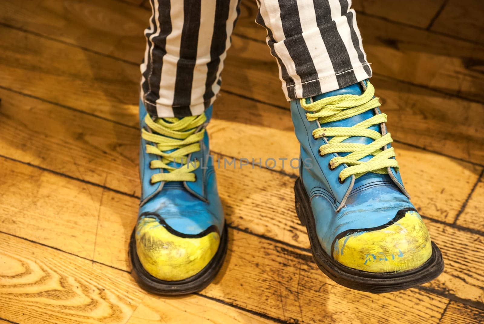 Female legs with colored shoes on wooden floor