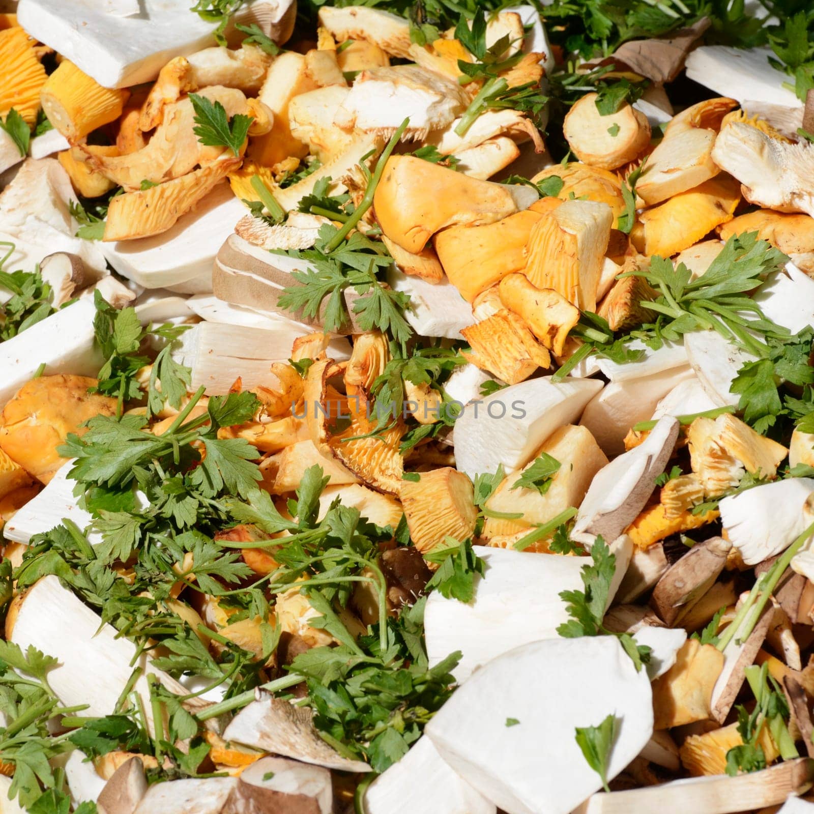 Various sliced mushrooms with parlsey and other herbage sold at the market