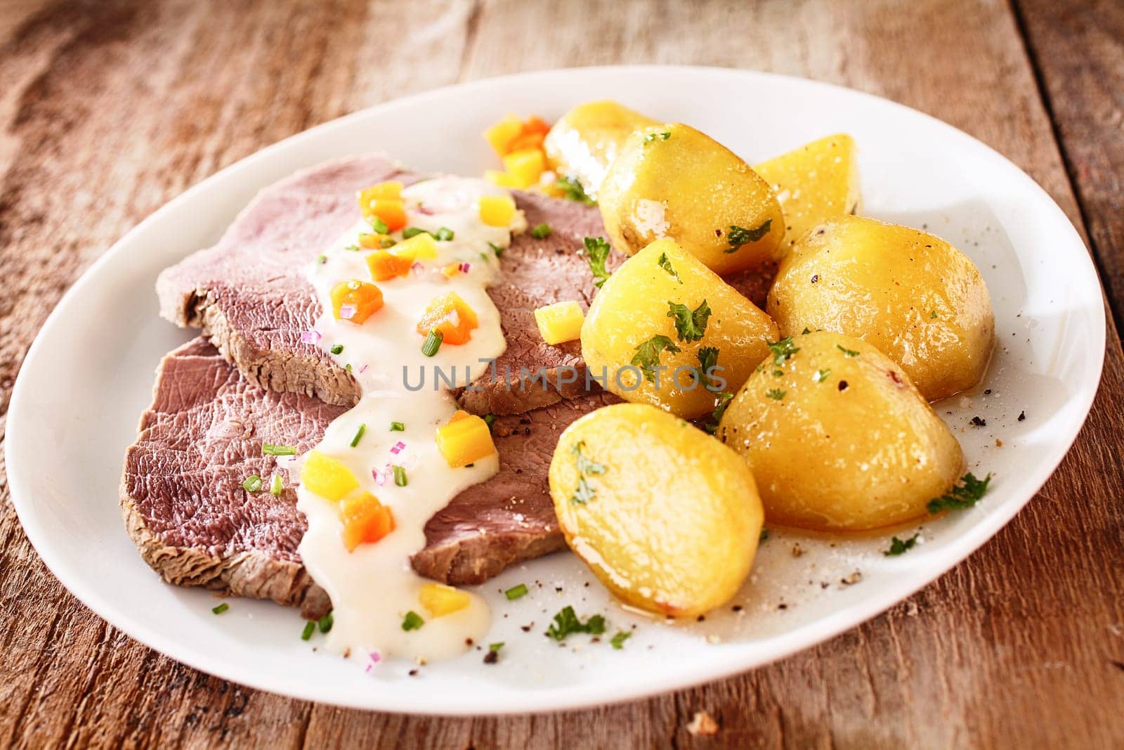 Sliced lean cap of rump served with delicious golden roast potatoes sprinkled with chopped parsley and topped with sour cream or creamy moyonnaise sauce