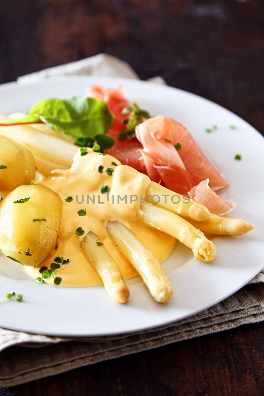 Asparagus spears , ham and chives served with a topping of creamy mayonnaise and potatoes for a delicious meal