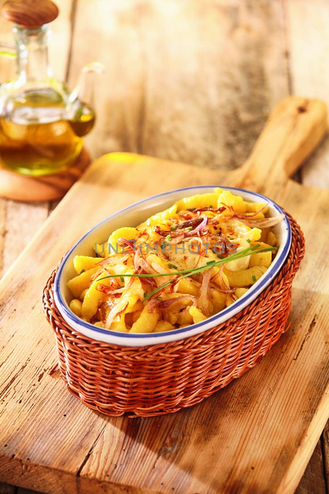 Dish filled with golden deep fried German spatzle, or egg noodle dumplings garnished with fresh chives