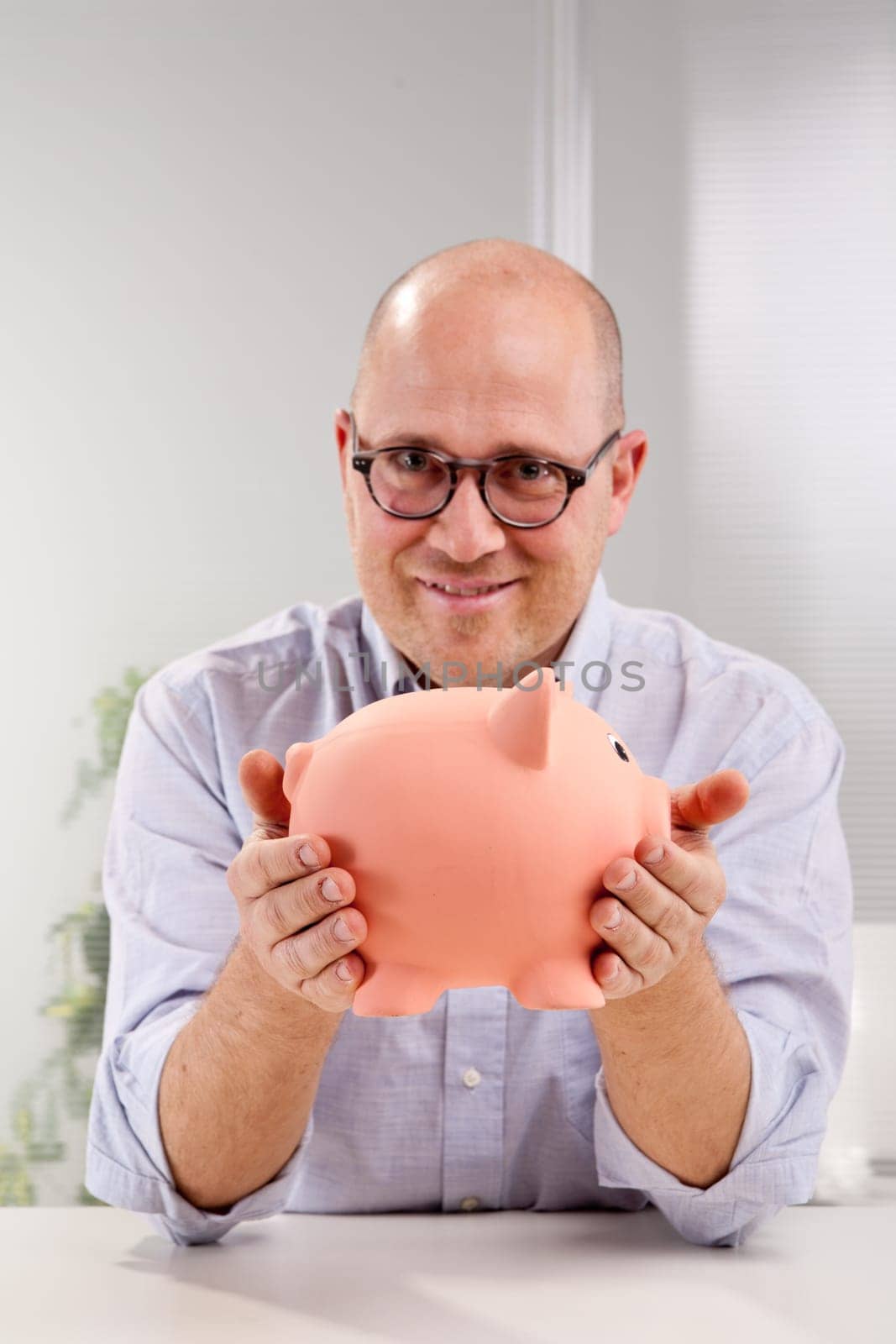 A funny bald clerk urges you to put your money in the piggy bank and save.