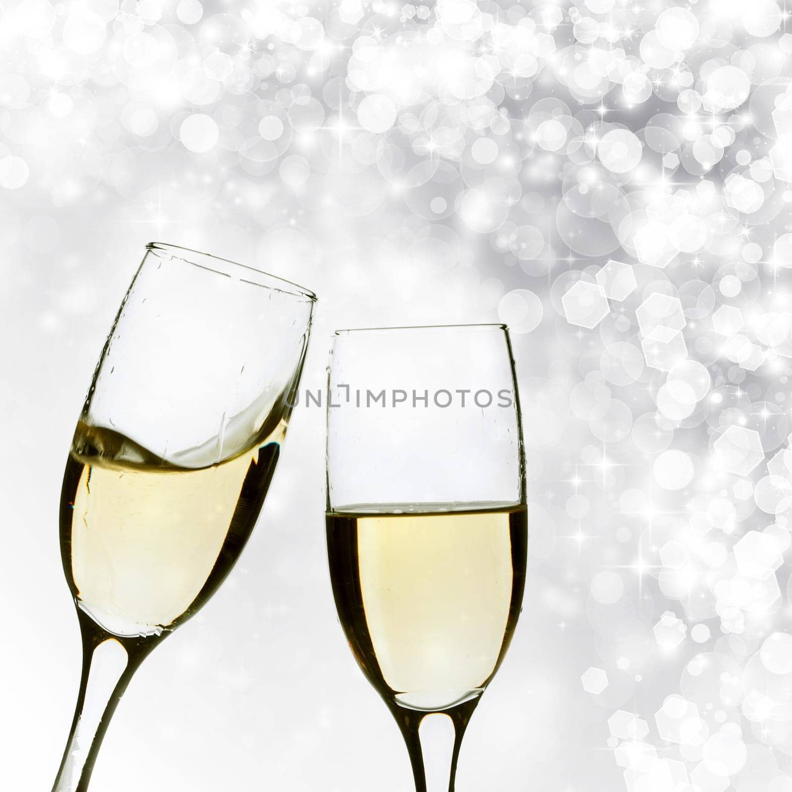 Glasses with champagne against silver holiday lights