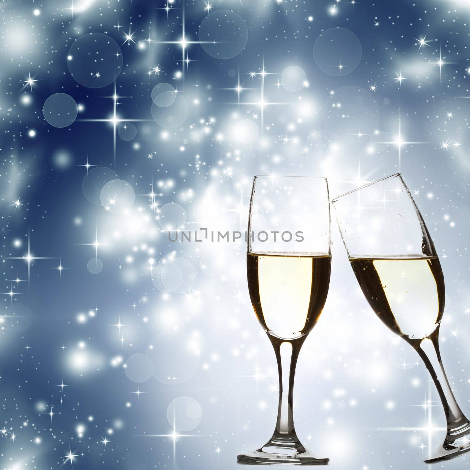 Glasses with champagne against blue holiday lights and stars