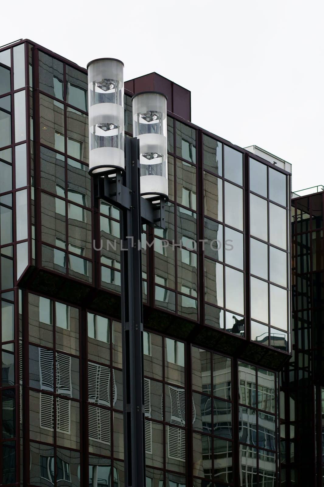 Die abstrakte Reflektion von Straßenlaternen in der Glasfassade eines modernen Hauses.