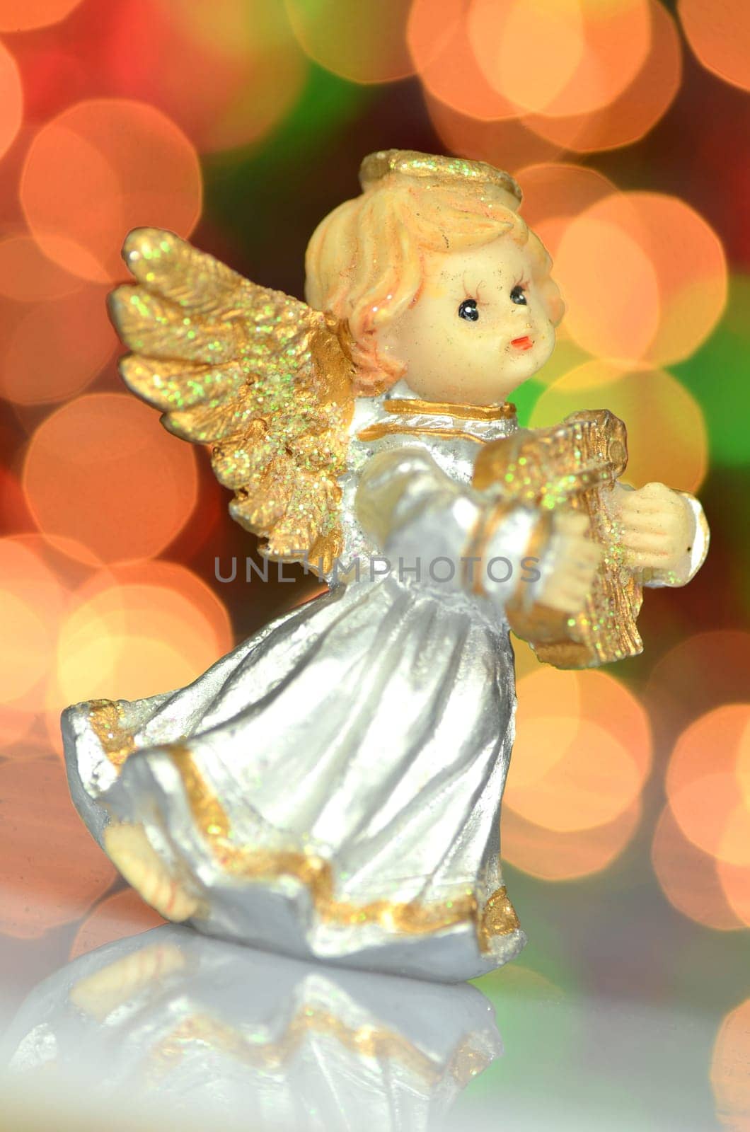 christmas decoration, figure of little angel playing the harp against bokeh background