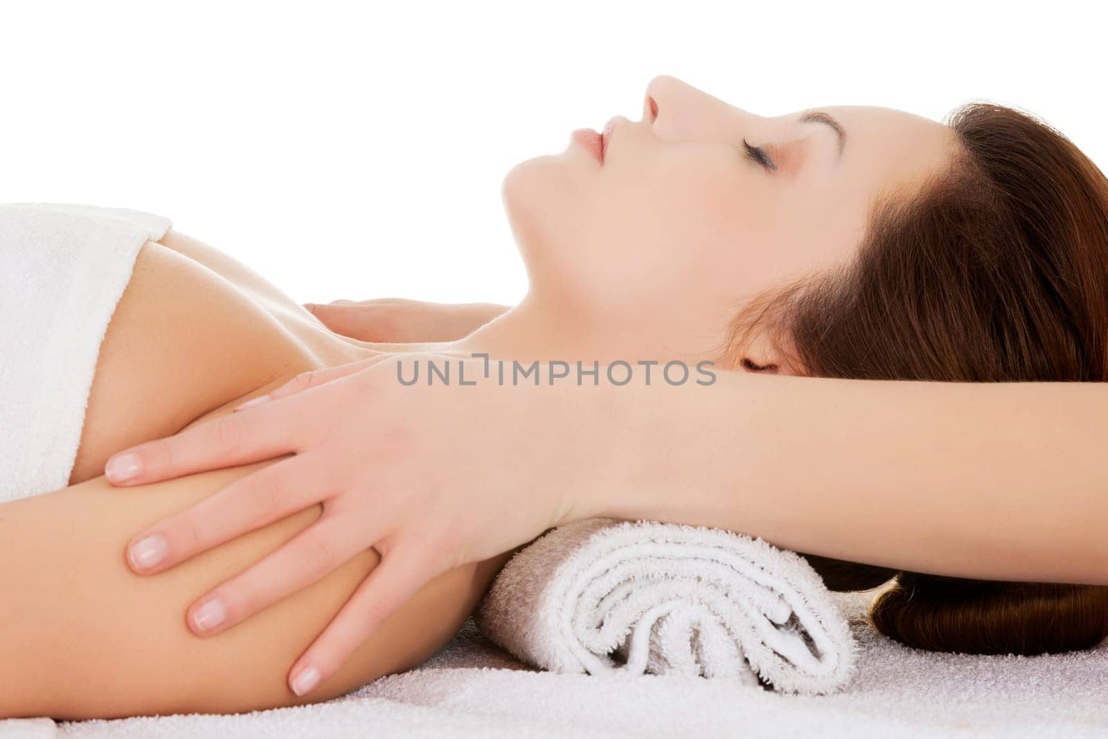 beautiful relaxed young woman enjoy receiving face massage at a spa saloon. isolated on white.