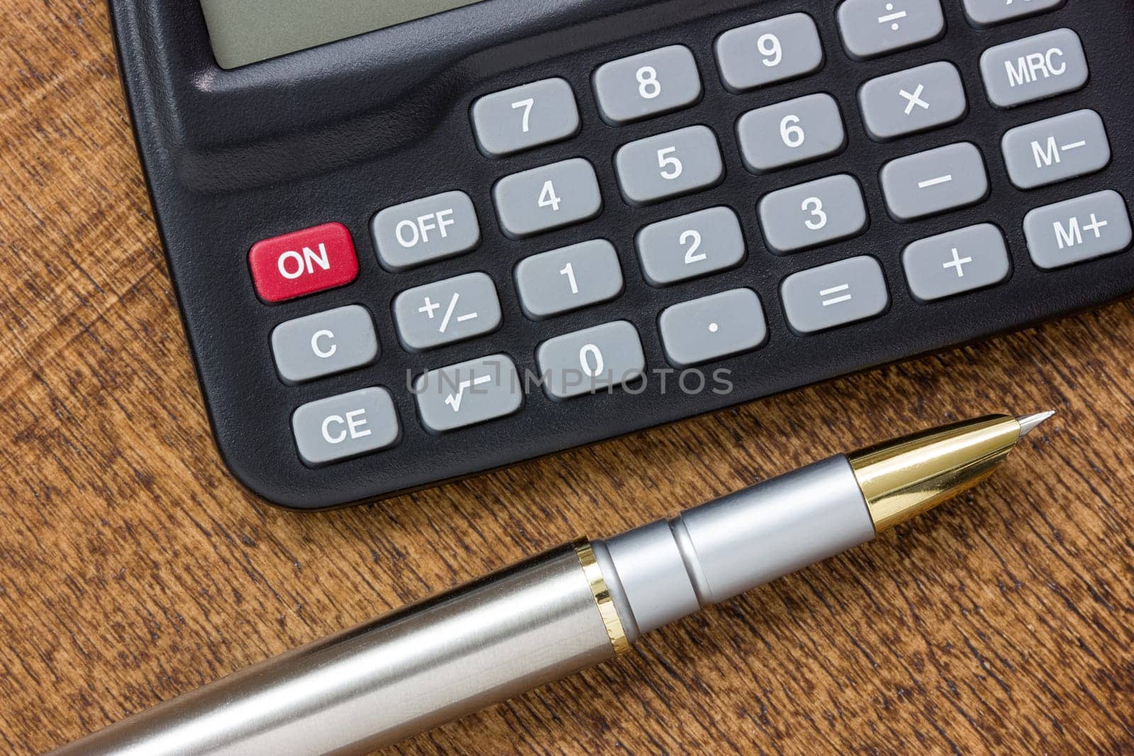 Adding up figures concept with modern calculator and pen on the table