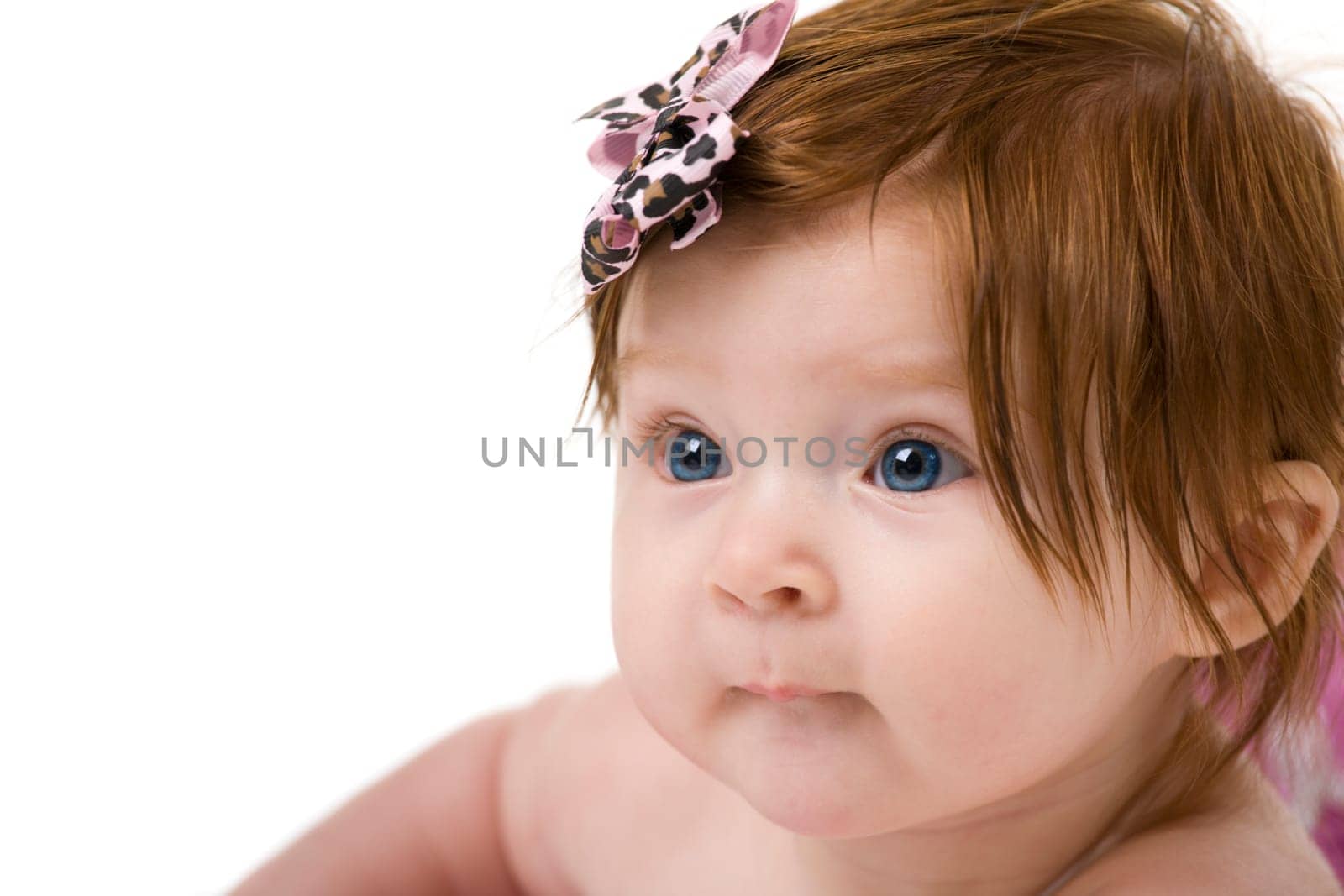 Portrait of a beautiful redheaded baby girl. Isolated on white background