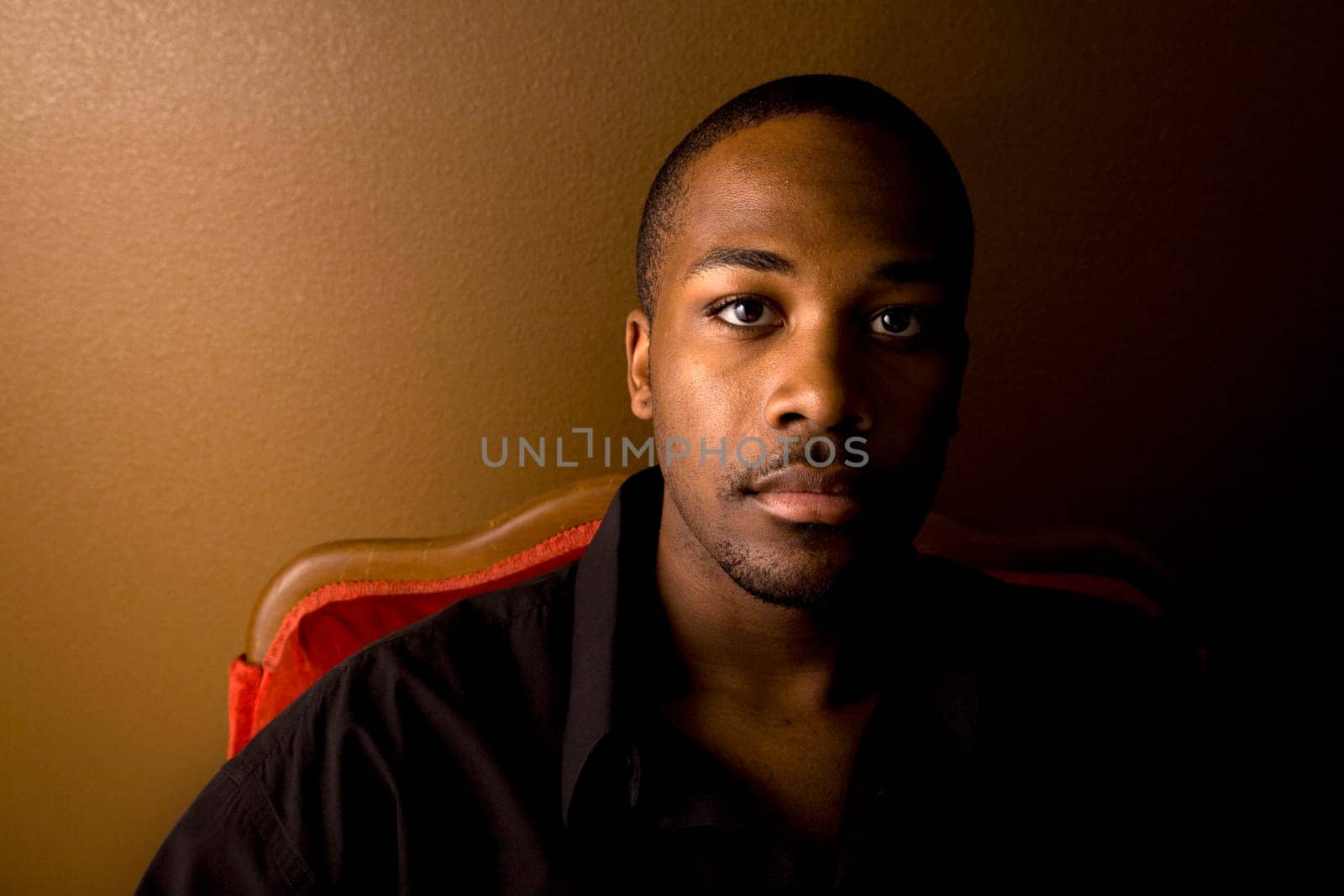 Portrait of a handsome young black man with dark background