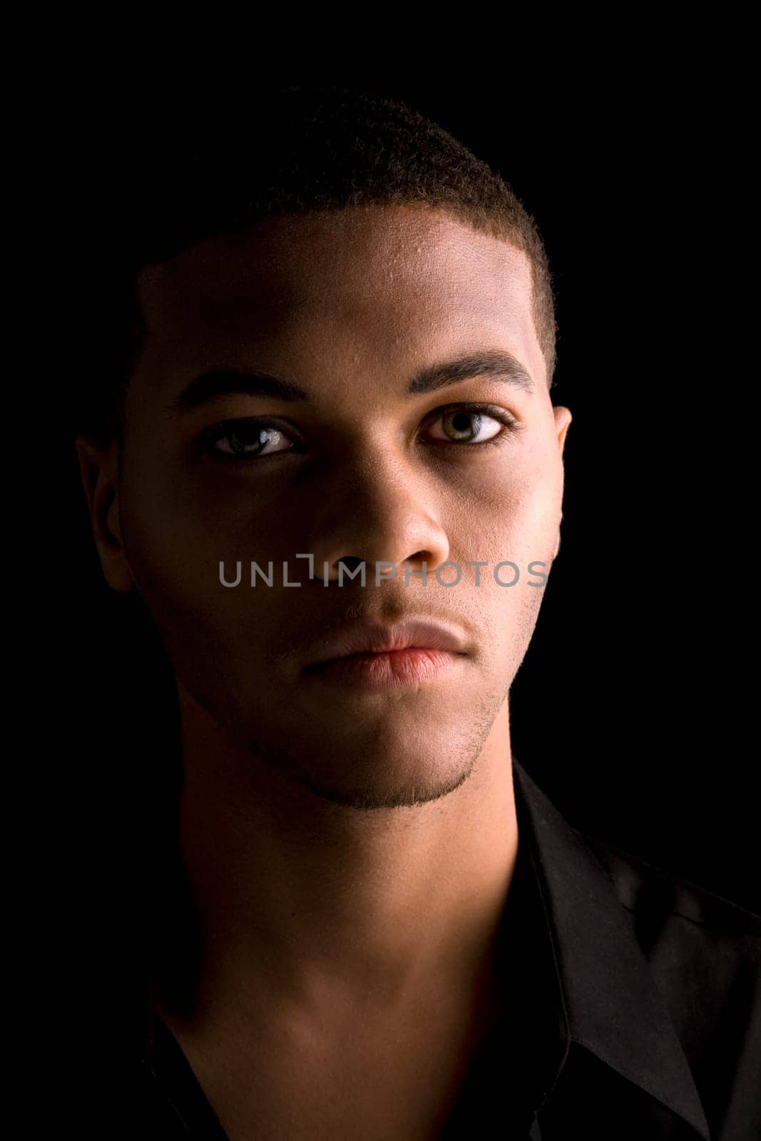 Portrait of a handsome young black man with dark background