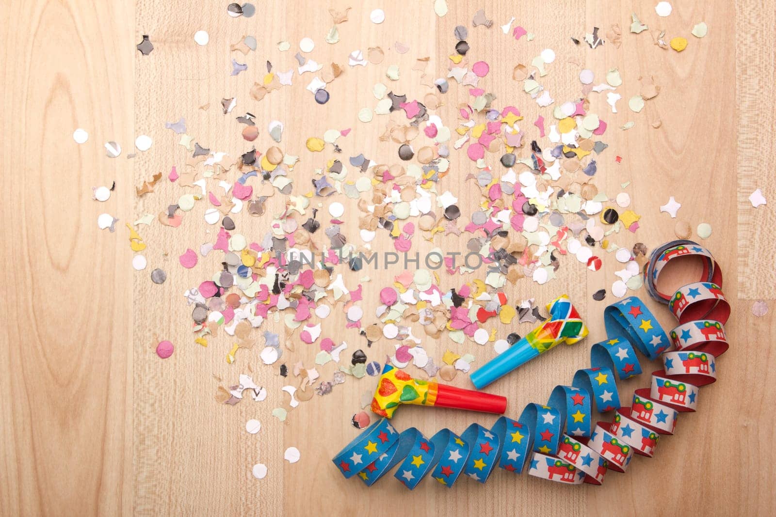 Streamers and confetti on wooden background
