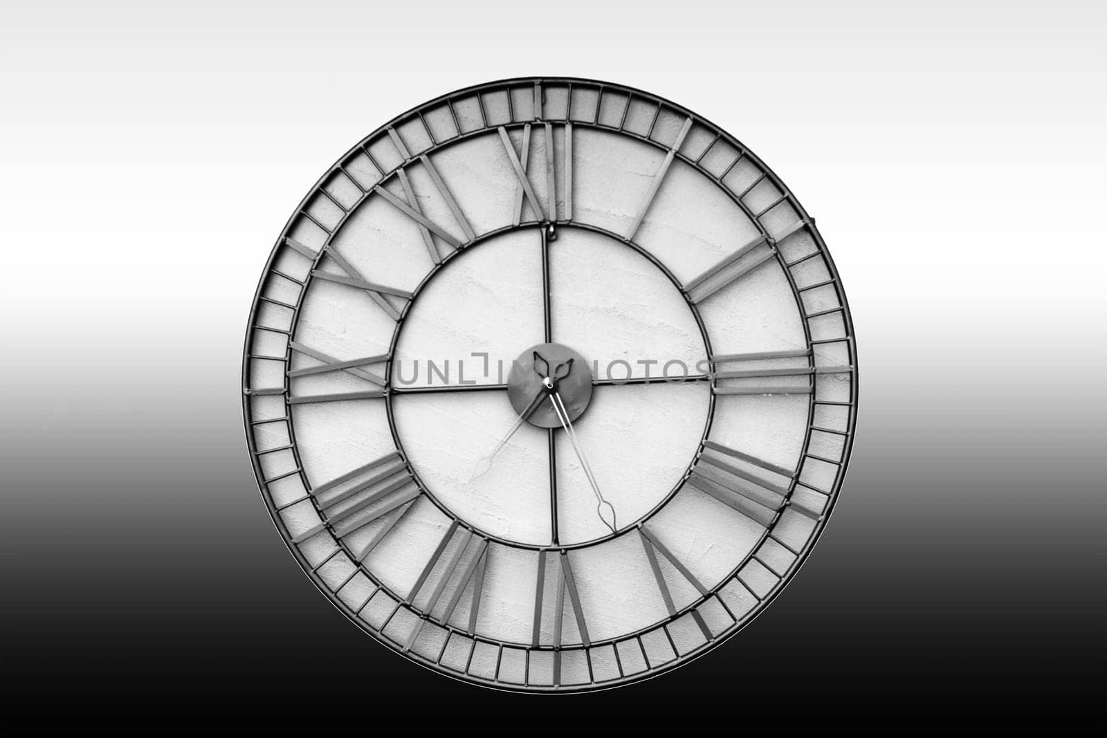 The close-up of an isolated wall clock against a homogeneous background.