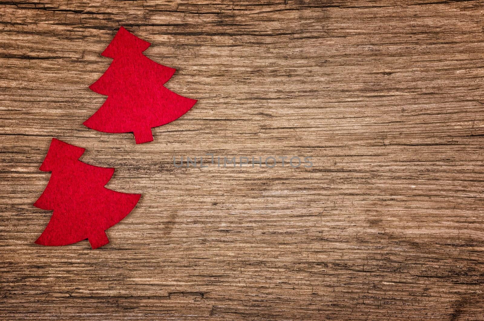 Rustic wooden background with two red Christmas trees