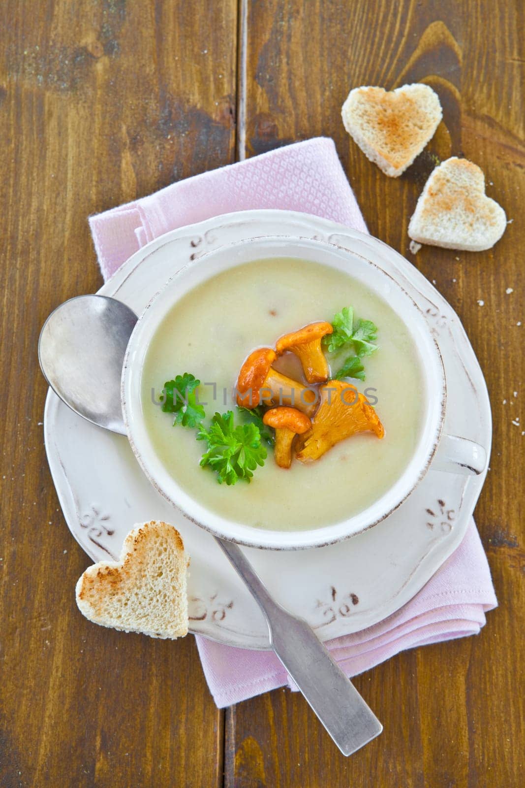 Creamy mushroom soup in cup with fresh chanterelles
