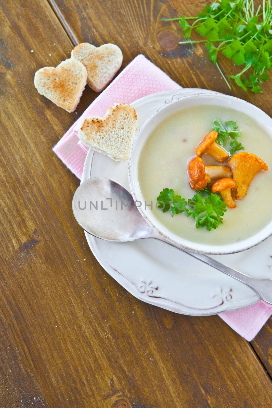 Creamy mushroom soup in cup with fresh chanterelles