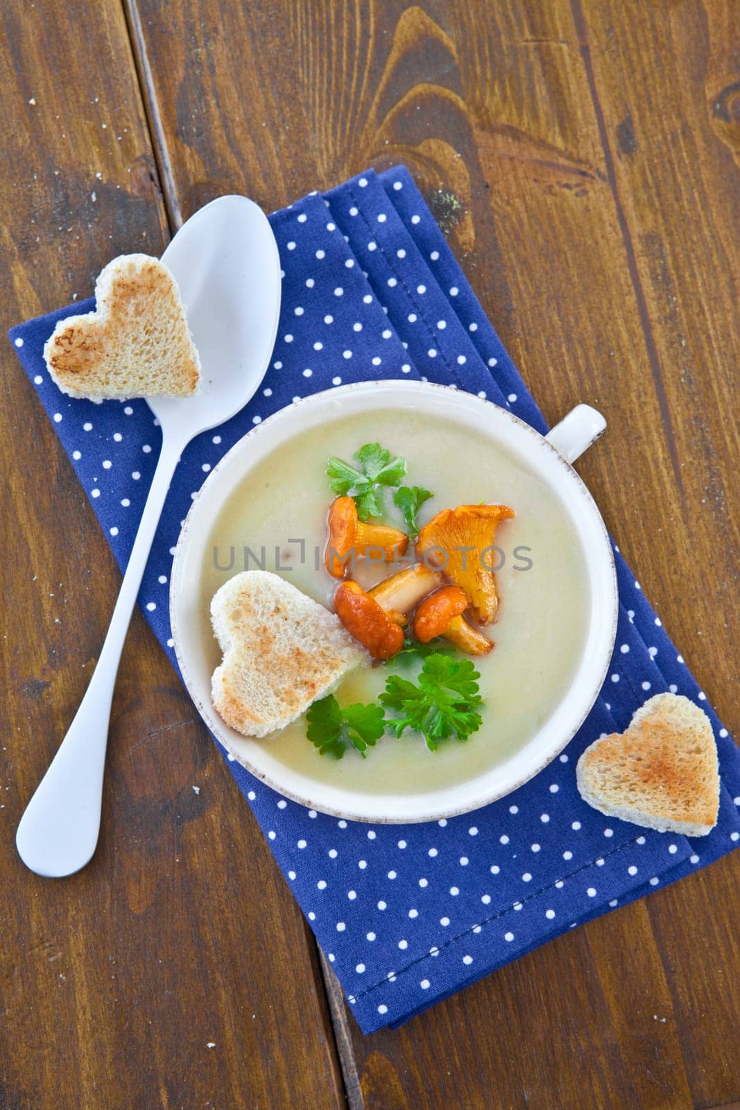 Creamy mushroom soup in cup with fresh chanterelles
