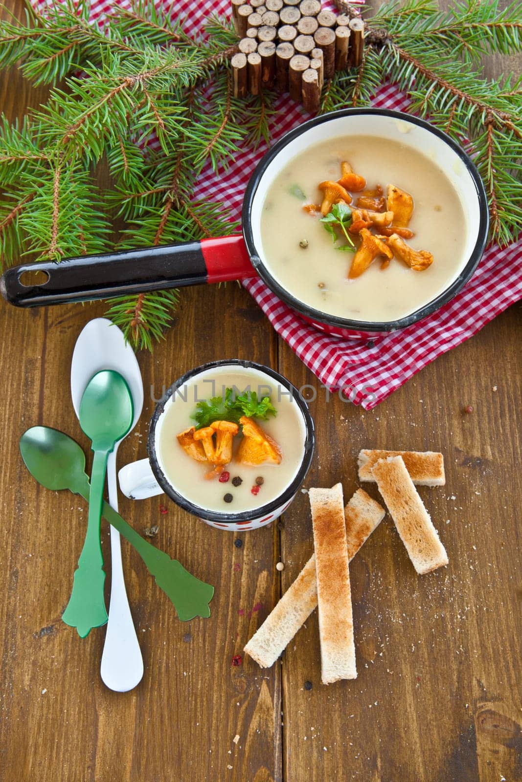 Creamy mushroom soup in cup with fresh chanterelles