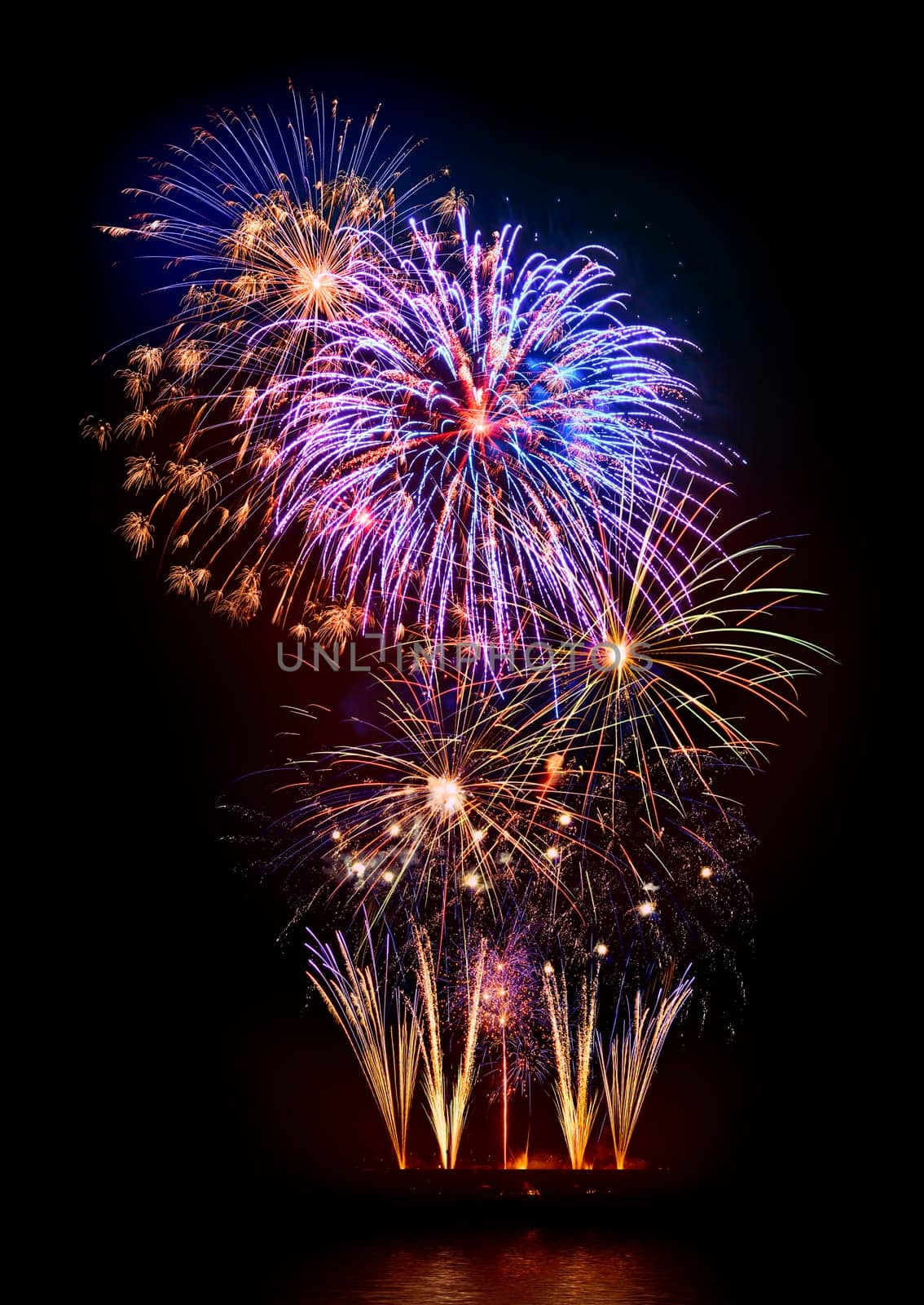 Fantastic colorful fireworks on black with reflection on water