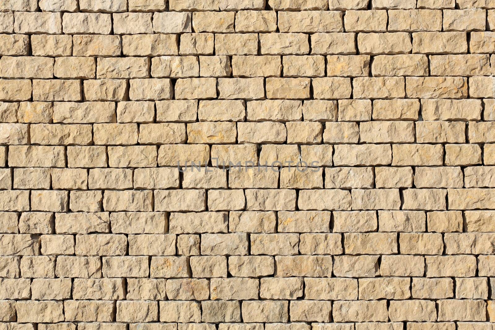 Detail of a outdoors wall made with stone stacked.